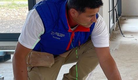 Homme en train de mesurer au sol pour un chantier de plâtrerie