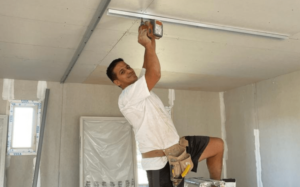 Artisan plaquiste entrain de réaliser des travaux de plâtrerie